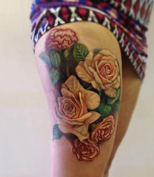 Tatuaggio rosa e fiore di garofano sulla coscia