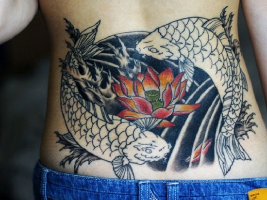 Tatuaggio di pesce koi nella parte bassa della schiena con loto