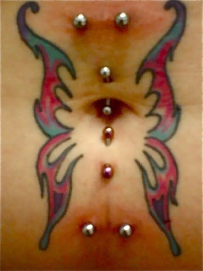 Piercing all'ombelico con tatuaggio a farfalla