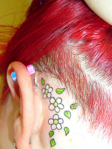 Tatuaje de margarita en la parte posterior de la oreja