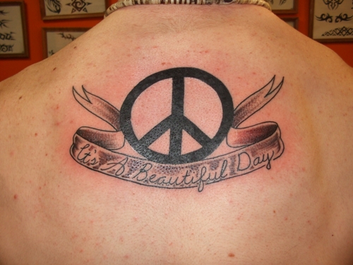 Tatuaggio con segno di pace e striscione