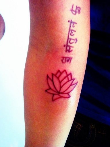 Tatuaje en sánscrito, flor de loto en el brazo