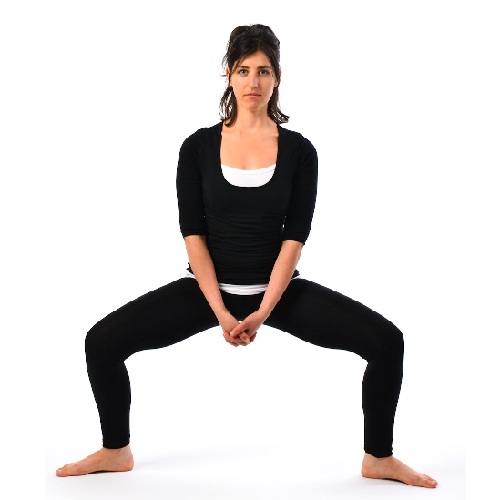 La postura de yoga en cuclillas y levántate