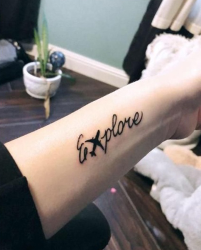 Tatuaje de letra E aventurera en el brazo