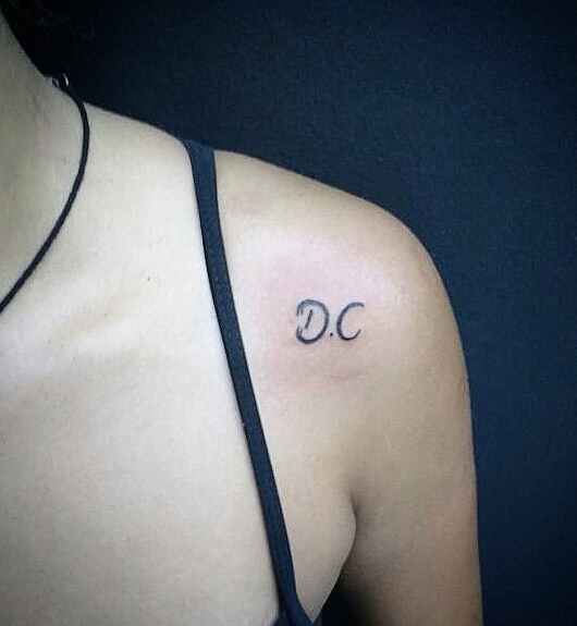 Tatuaje de D y C en el hombro