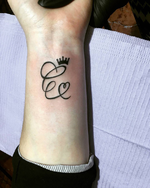 Diseño de tatuaje de letra C con una corona