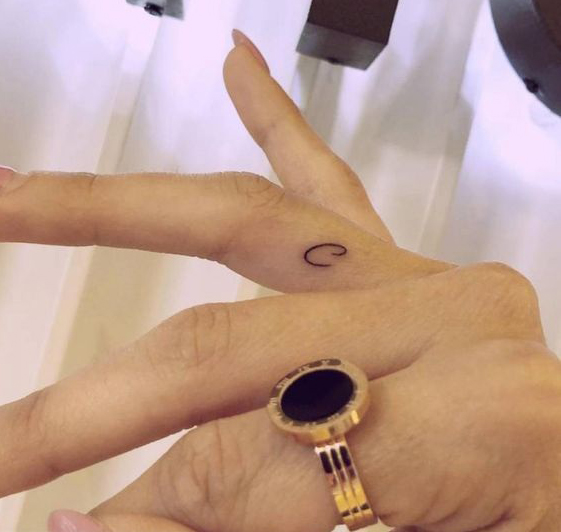 Tatuaje de letra C en el dedo