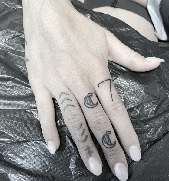 Diseño de tatuaje de letra C en el dedo medio