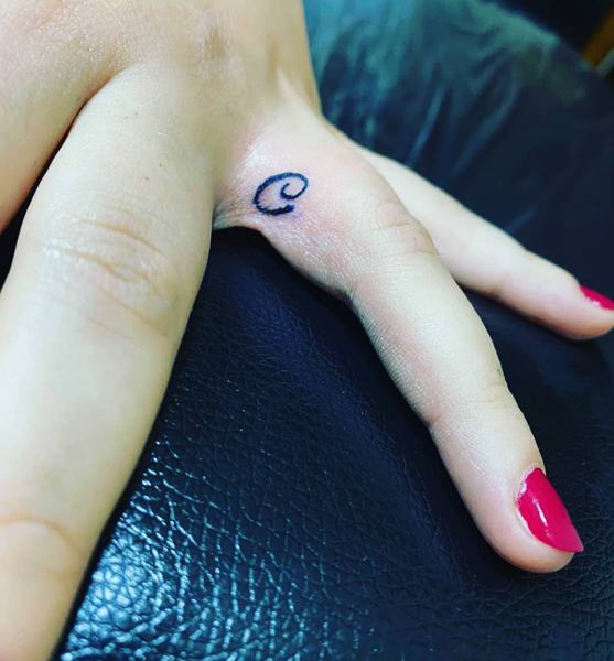 Tatuaje de la letra C del dedo anular