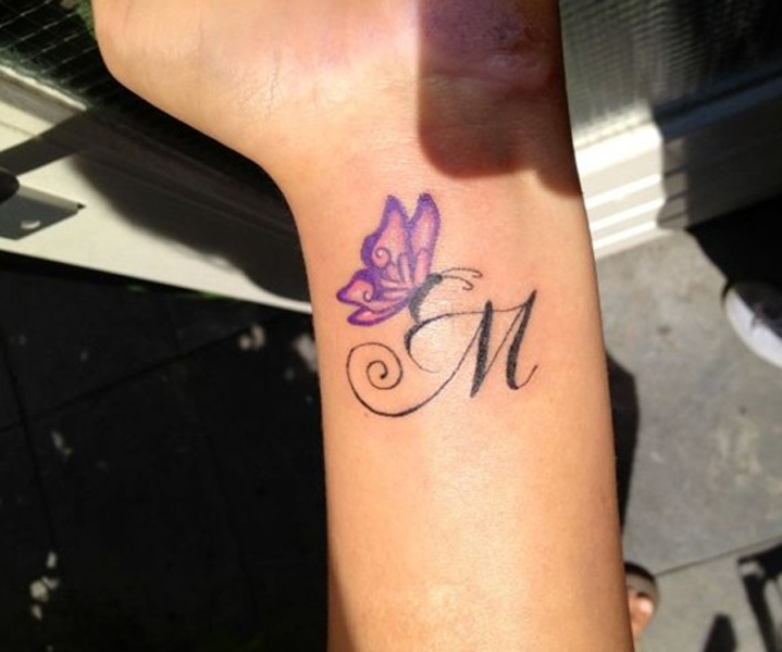 Tatuaggio affettuoso lettera M con una farfalla