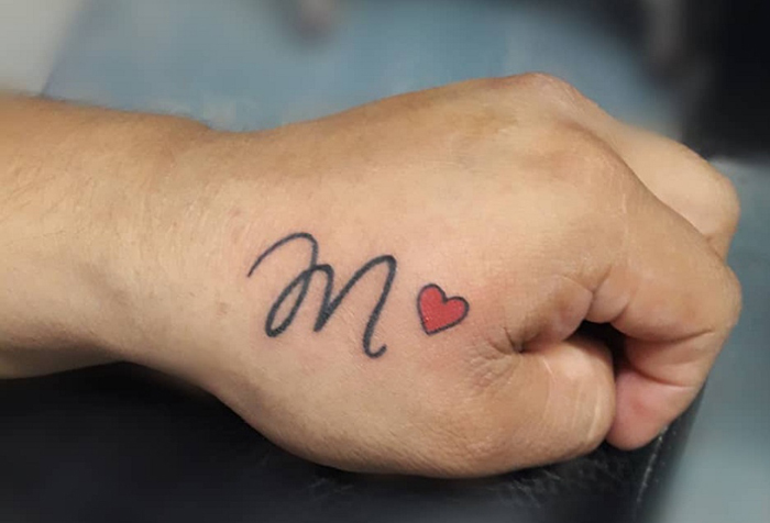 Tatuaggio espressivo carattere M con un cuore