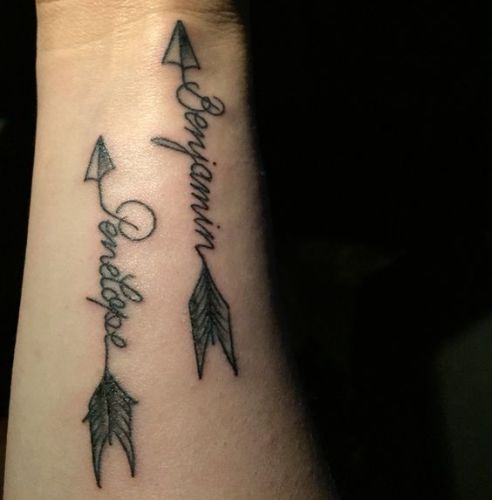 I disegni del tatuaggio del nome della freccia sulle braccia