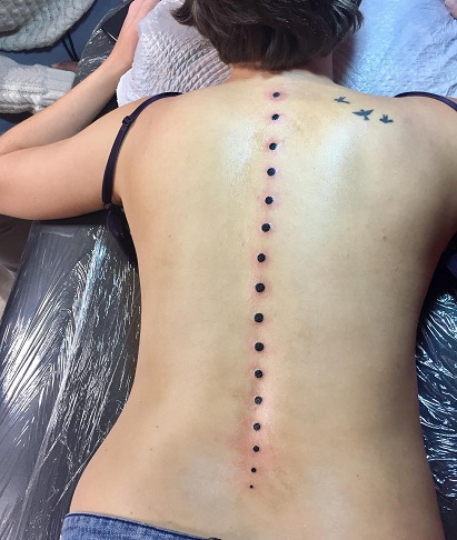 Tatuaggio spinale punti neri