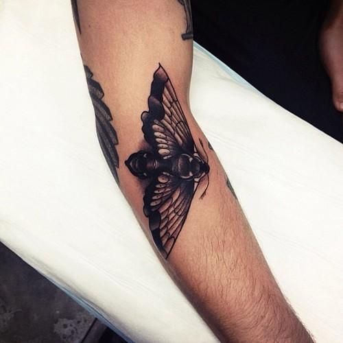 Tatuaje en el brazo, polilla negra