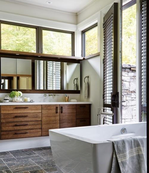 חדר אמבטיה בארונות עץ כהה אפור קיר אבן בחוץ deta