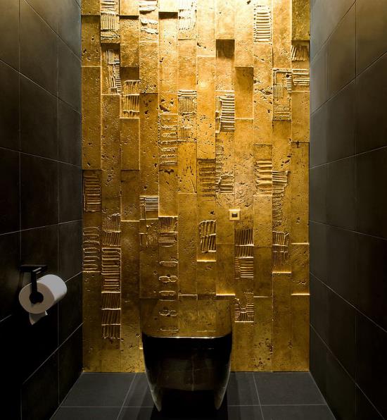 חדר אמבטיה בשירותים בשחור וזהב קיר אחד בציפוי זהב משטח מעניין שני קירות אחרים רצפת קערת אסלה שחורה