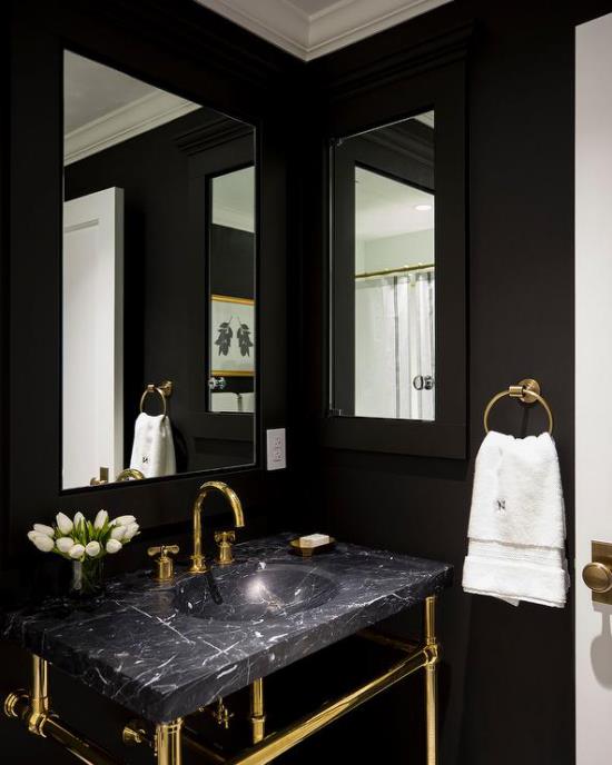 חדר אמבטיה ביחידת איפור שחורה וזהב משיש שחור אור טבעי שתי מראות בד צבעוני לבן