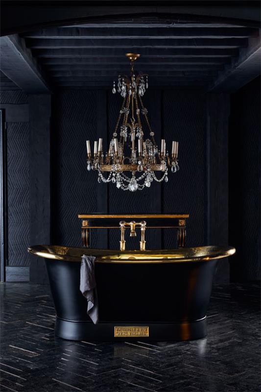חדר אמבטיה בשחור וזהב, אווירה כהה, אמבטיה עצמאית, אלמנטים מזהב מבריק, ונברשות מפוארות מעל