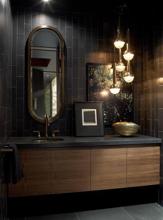 חדר אמבטיה בשחור וזהב מקורות אור שונים משלבים מנורת תלייה מובנית בחדר