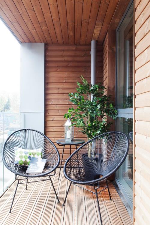 רעיונות למרפסת עיצוב מרפסת קטנה צמח ירוק עץ פוריסטי שתי כורסאות עשויות מתכת