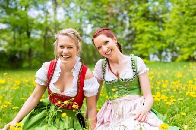 צעירות בבגדים בוואריים מסורתיים - dirndl או tracht - על אחו באביב