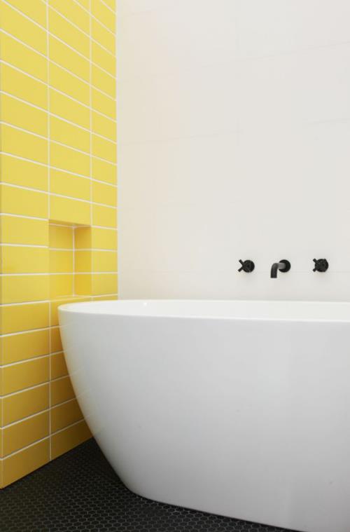 הדגשת אריחים בחדר האמבטיה קיר מבטא יצירתי ונועז בצהוב שמש