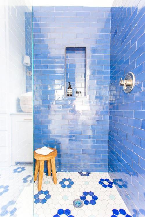 מבט אריחים בחדר האמבטיה עיצוב אמבטיה יצירתי ונועז מושך בכחול שמיים עם אריחי ריצוף מבריקים שרפרף עץ