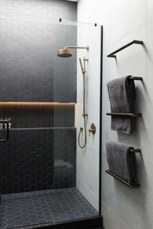 מבטאי אריחים בחדר האמבטיה יצירתיים ונועזים תא מקלחת אריחים שחור משושה, קיר זכוכית, מגבות אפורות, קיר אפור