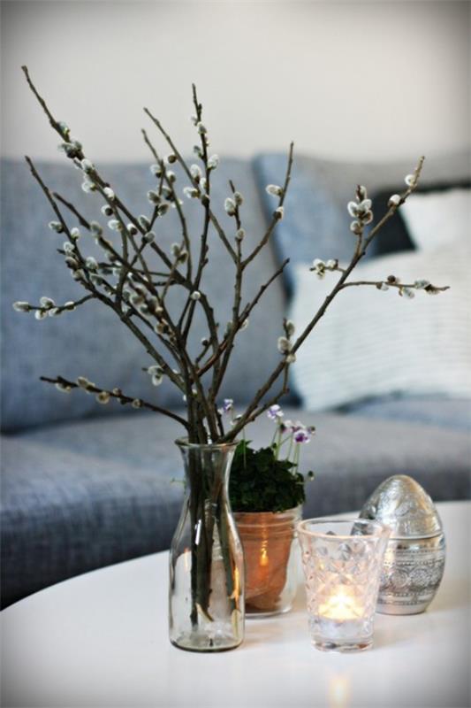 קנה קישוט אביב עם ענפי ערבה של כוס מסודרים באגרטל על שולחן הקפה מחנות פרחים