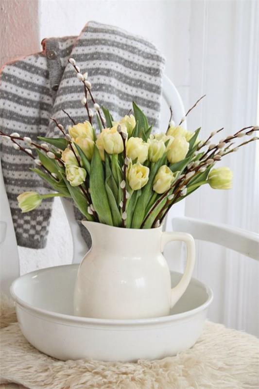 עיטור אביב עם ערבת כוס מסודרת בכד חרסינה לבן עם צבעונים צהובים