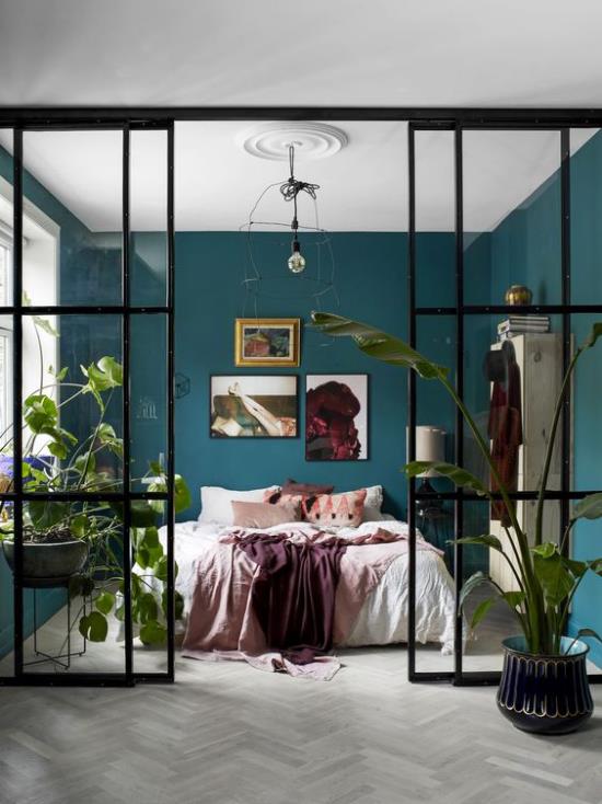 קירות זכוכית בחדר השינה יוצרים נווה מדבר ירוק נטול סף בעציצים קירות כחולים-ירוקים