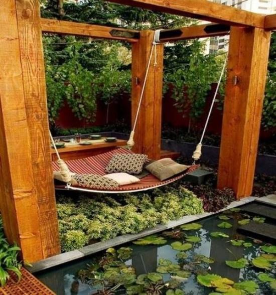 מיטה תלויה מחוץ לעיצוב יוצא דופן בסגנון יפני ממש על הבריכה, צמחים ירוקים רבים כריות נוי