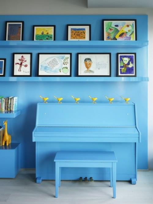 גלריה לאמנות עם מסגרות תמונות על הקיר רהיטים כחולים