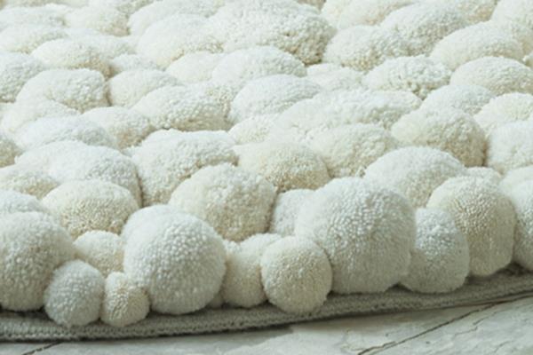 שטיחי מעצבים עגולים של MYK מפונפנים מתנפנפים על לבנים רכים מחובקים