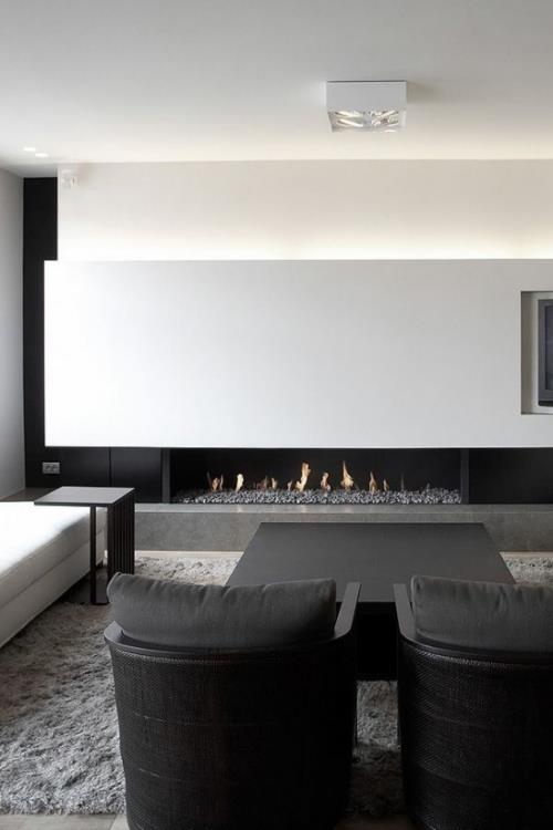 מינימליזם בסלון עיצוב חדר מושלם בצבע אפור לבן שתי כורסאות שחורות באח הקדמית ברקע