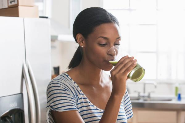 מיץ סלרי אישה צעירה שותת ירוק ספוג בריא התאמה טבעית לנס פלא