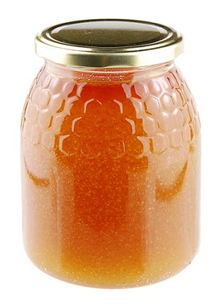 Miel casera en un frasco de vidrio sobre blanco