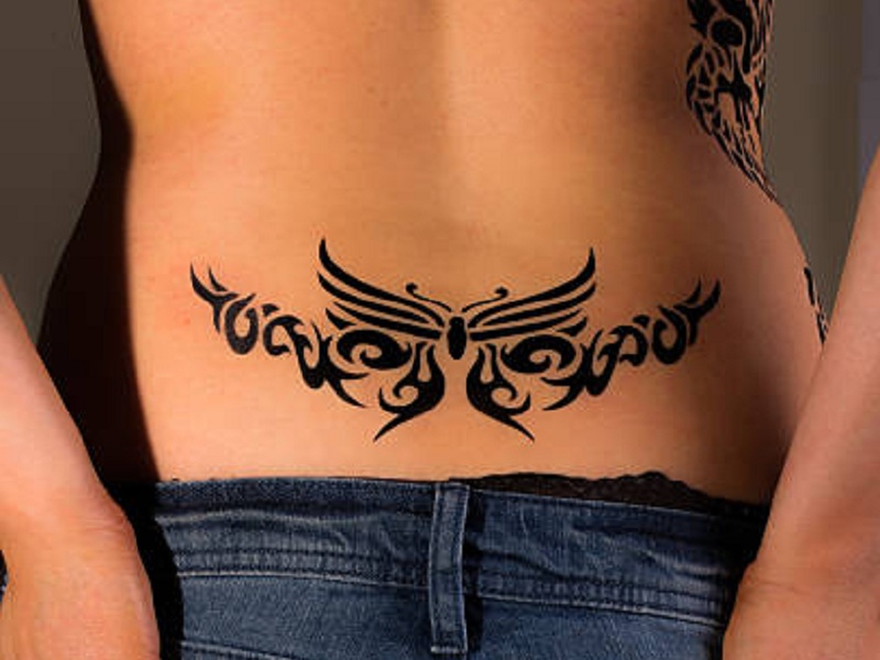 Una imagen de alta resolución de una niña con un tatuaje tribal en la espalda baja