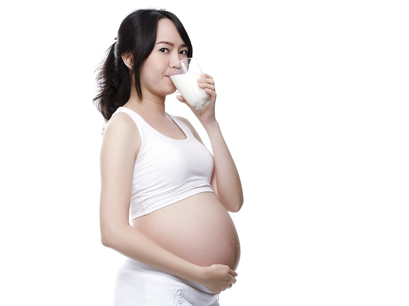 Donna incinta che beve latte