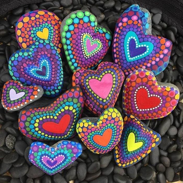 ציור יד לבבות צבעוניות על אבנים