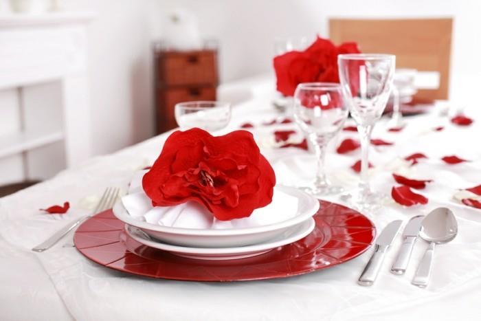 שולחן אוכל מעוטר כלים עלי ורדים אדומים לבנים