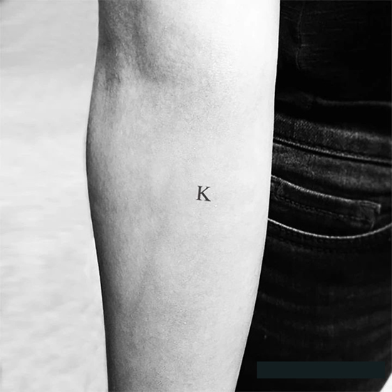 Tatuaggio con la K maiuscola vicino al gomito