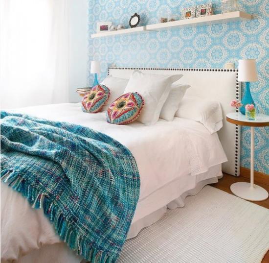 חדר שינה קטן מרחיב ויזואלית כריות נוי בכחול ולבן עם דפוסים אתניים