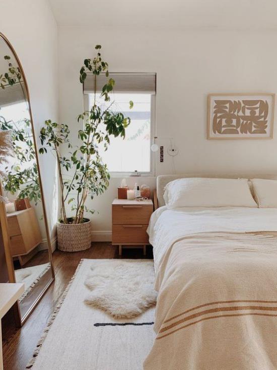 חדר שינה קטן מרחיב אופטית אווירה יפה צבעים בהירים ועציצים צמח בעציץ בפינה מול מראה החלון משמאל
