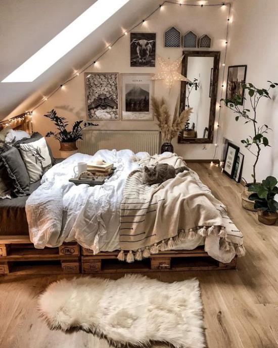חדר שינה קטן מתרחב ויזואלית מתחת לתקרה המשופעת יותר מדי אורות דקורציה תלויים שרשראות