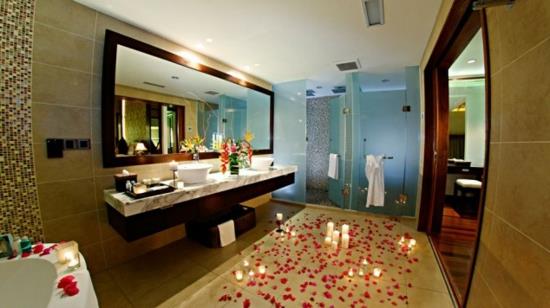 נרות אמבטיה רומנטיים ועלי כותרת פרחים על הרצפה