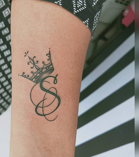 Elegante diseño de tatuaje de S en el brazo