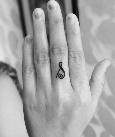 Diseño de tatuaje inicial S en el dedo