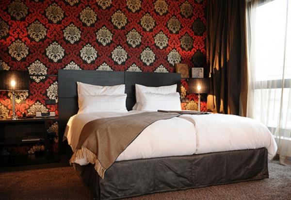 ריהוט חדר שינה עם טפטים קלאסיים עם מיטה זוגית אורות קונסולות ליד המיטה
