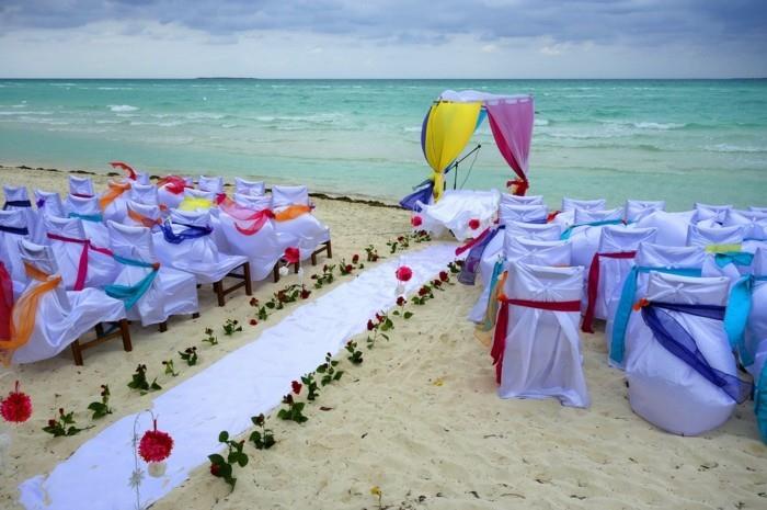 חתונה על החוף עם בדים ופרחים צבעוניים